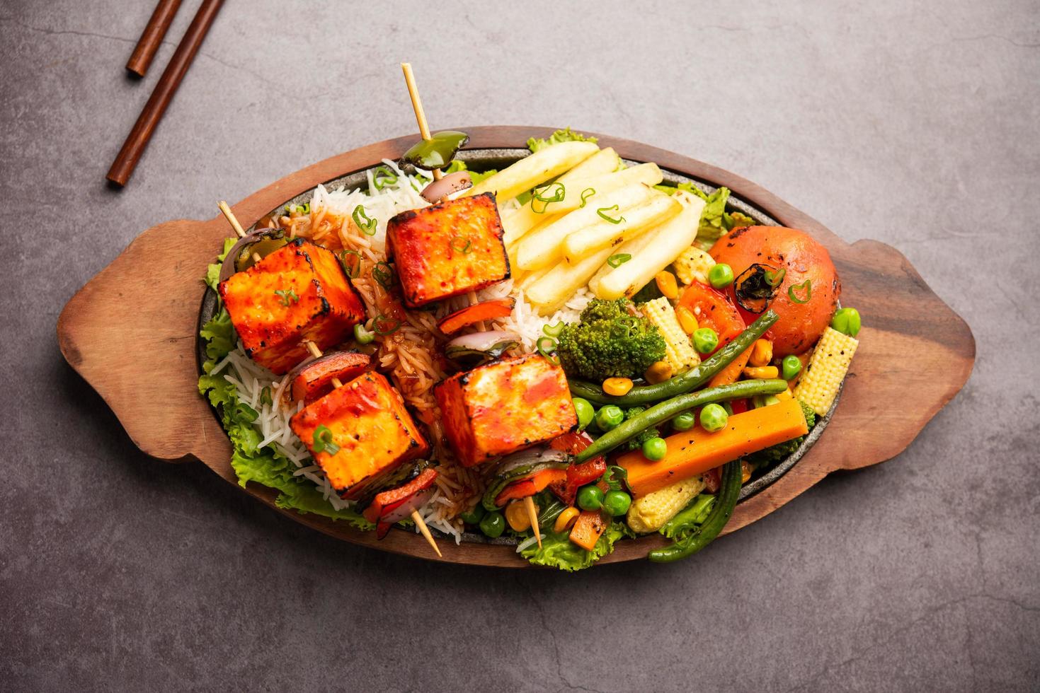 paneer sizzler é uma versão indiana com queijo cottage, salada servida escaldante em prato de pedra quente. foto