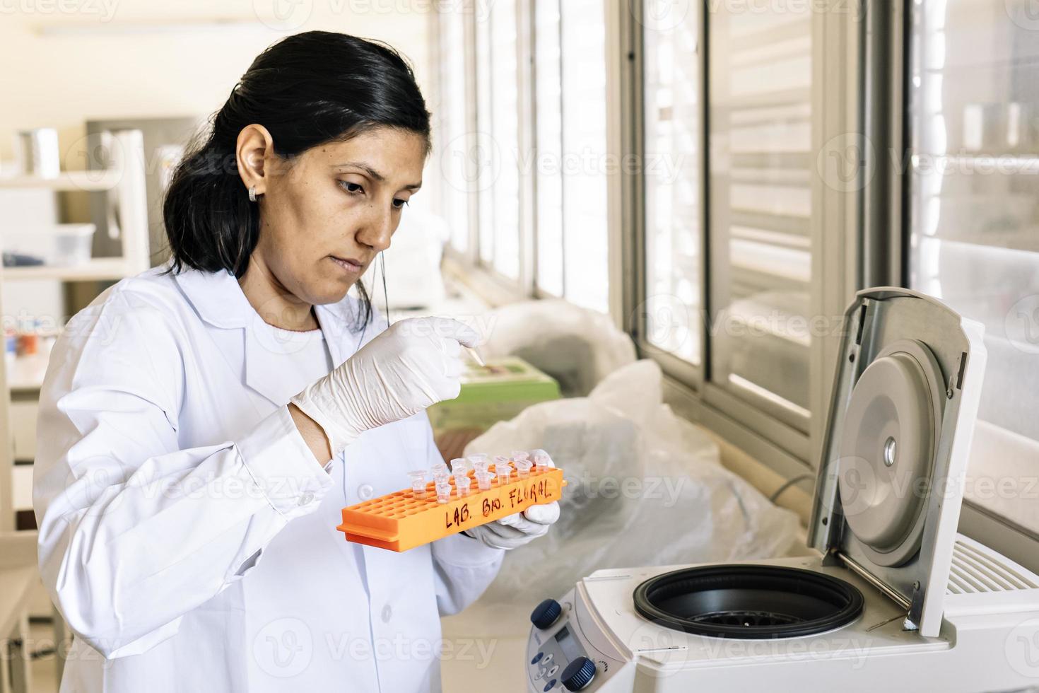 um pesquisador colocando amostras de dna em uma microcentrífuga foto