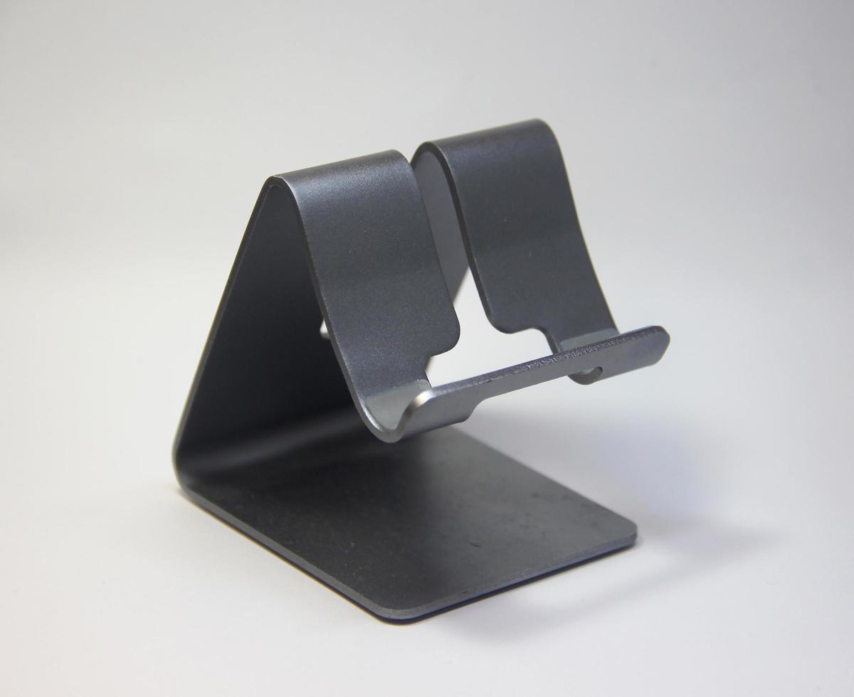 foto de exibição de suporte de mesa de telefone móvel de smartphone de metal pequeno isolado em fundo liso.