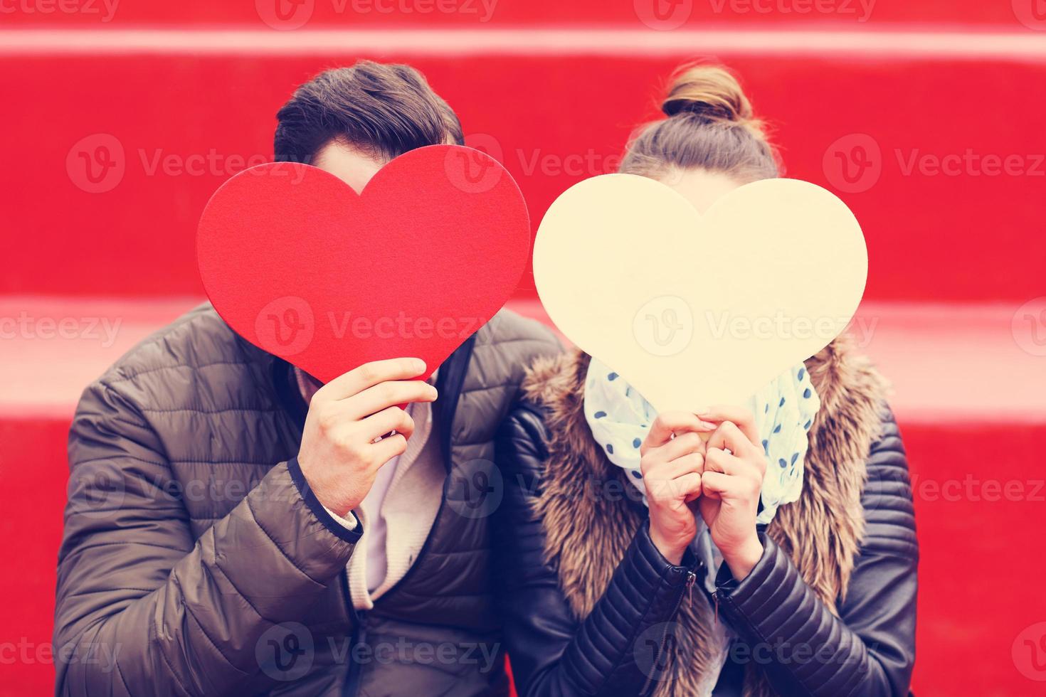 casal romântico segurando corações foto