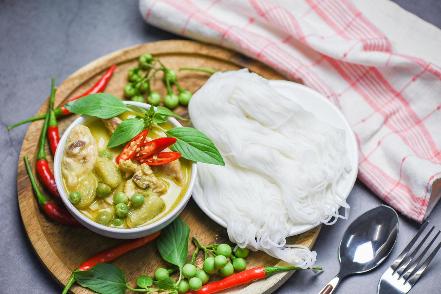 comida tailandesa frango curry verde na tigela de sopa e macarrão de arroz tailandês aletria com vegetal de erva ingrediente - comida asiática em cima da mesa foto