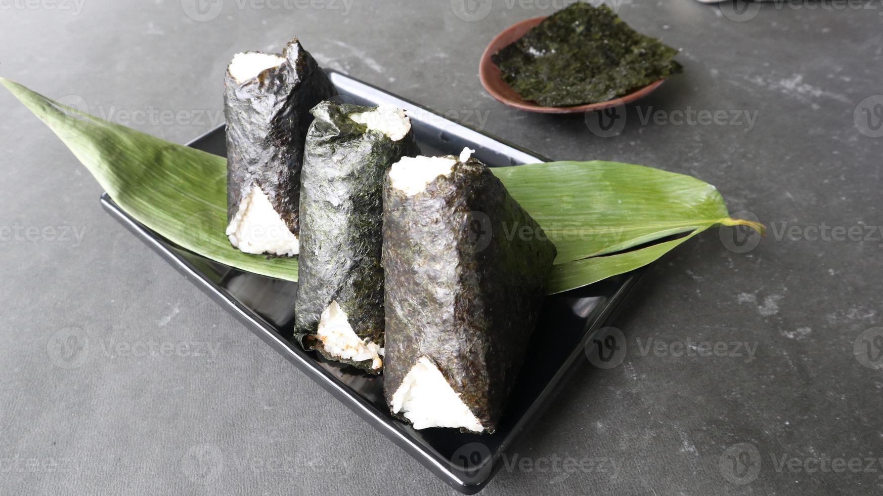 onigiri é comida japonesa, bolinho de arroz japonês, triângulo de arroz com algas marinhas, nori isolado com fundo foto