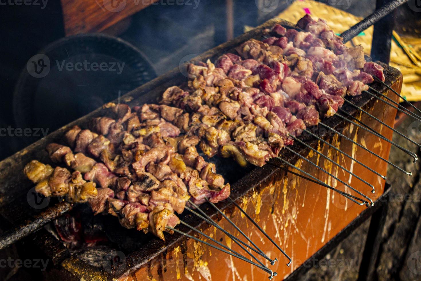 sate klatak ou sate kambing ou satay cabra, cordeiro, cordeiro ou carne de cabra satay com ingrediente de carvão em fogo vermelho grelhando por pessoas, indonésia cozinhando satay. com foco seletivo foto