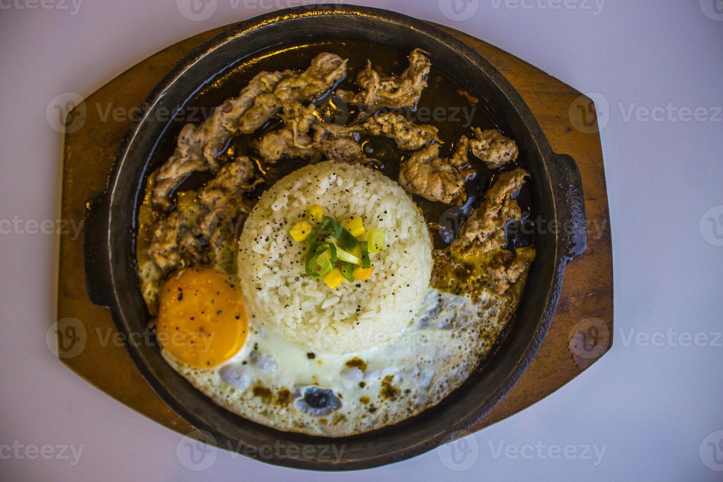 café da manhã com arroz, ovo frito e carne ou carne com enfeite de milho e alho-poró fechar placa quente isolada no fundo branco foto