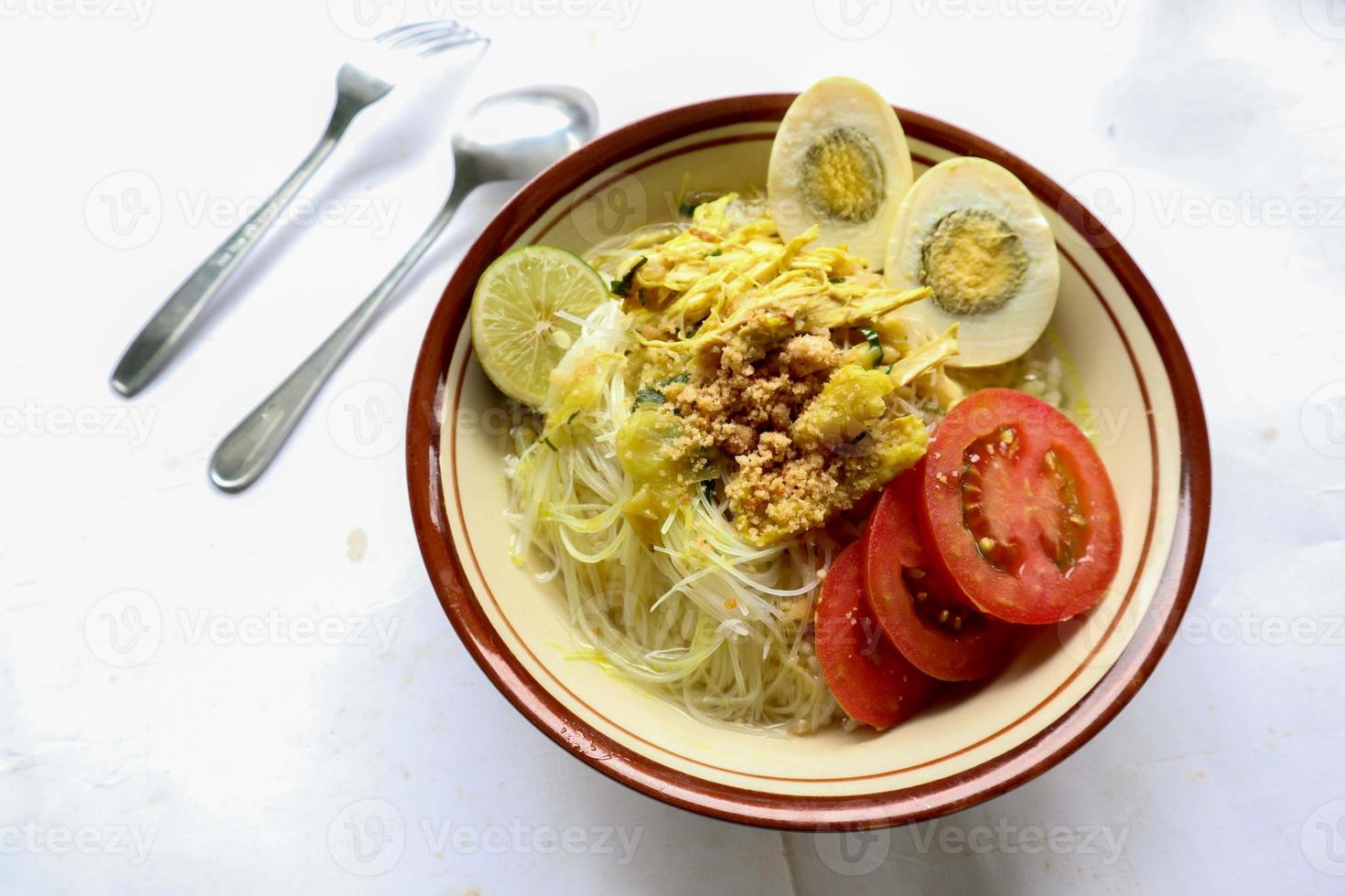 soto lamongan é um prato de sopa lamongan, leste de java, indonésia. feito de frango, aletria, ovo, broto de feijão, açafrão, o caldo e koya foto