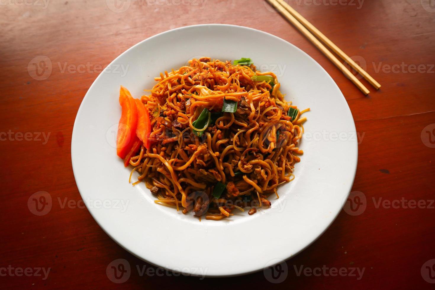 O yakisoba é o tradicional macarrão japonês frito, feito de macarrão, repolho, legumes e carne, temperado com molho de ostra ou molho de yakisoba. yakisoba servido no prato foto