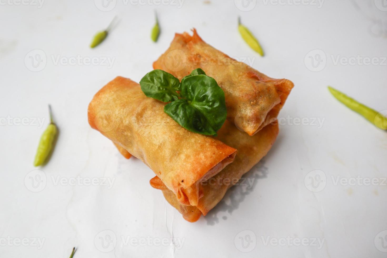 lumpia ou lunpia, é um lanche tradicional de rolinho primavera de semarang, indonésia. rolinhos primavera tradicionais feitos de ovos e frango ou camarão, brotos de bambu fritos. isolado no fundo branco foto