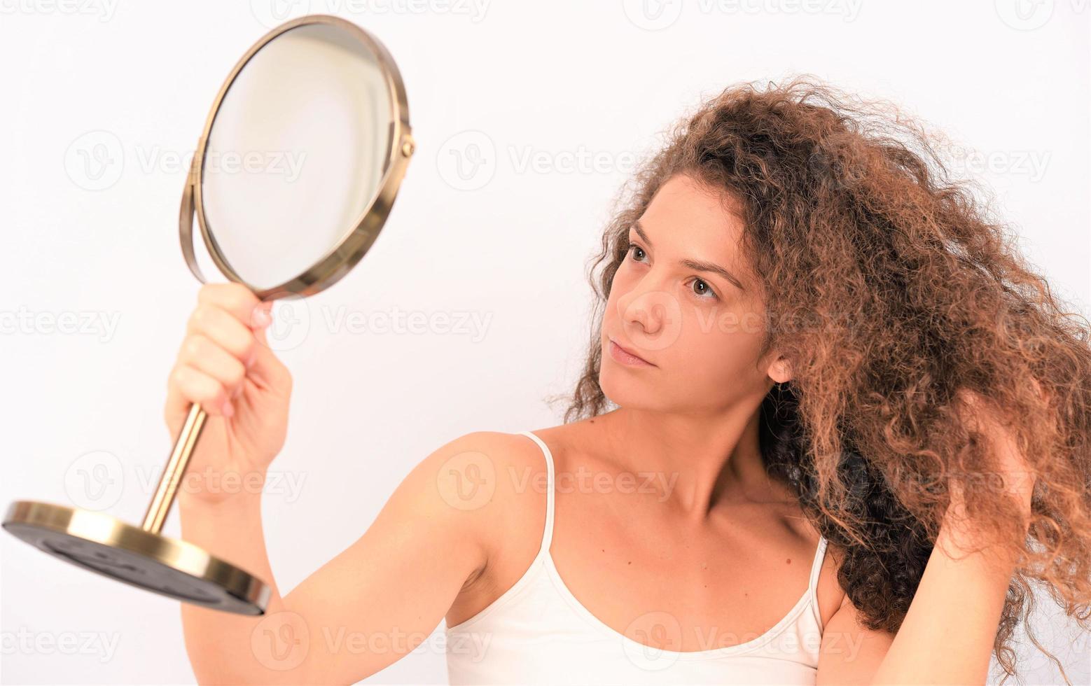 mulher com cabelo cacheado bagunçado em fundo branco foto