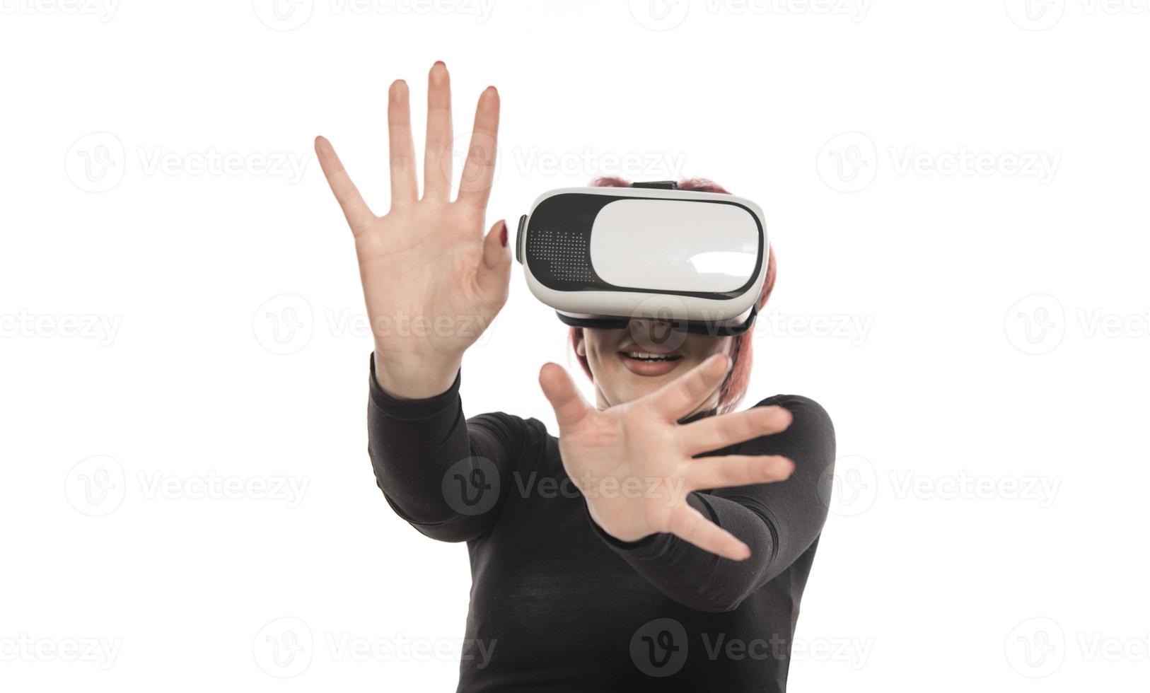 mulher muito bonita animada no fone de ouvido vr olhando para cima e tentando tocar objetos na realidade virtual foto