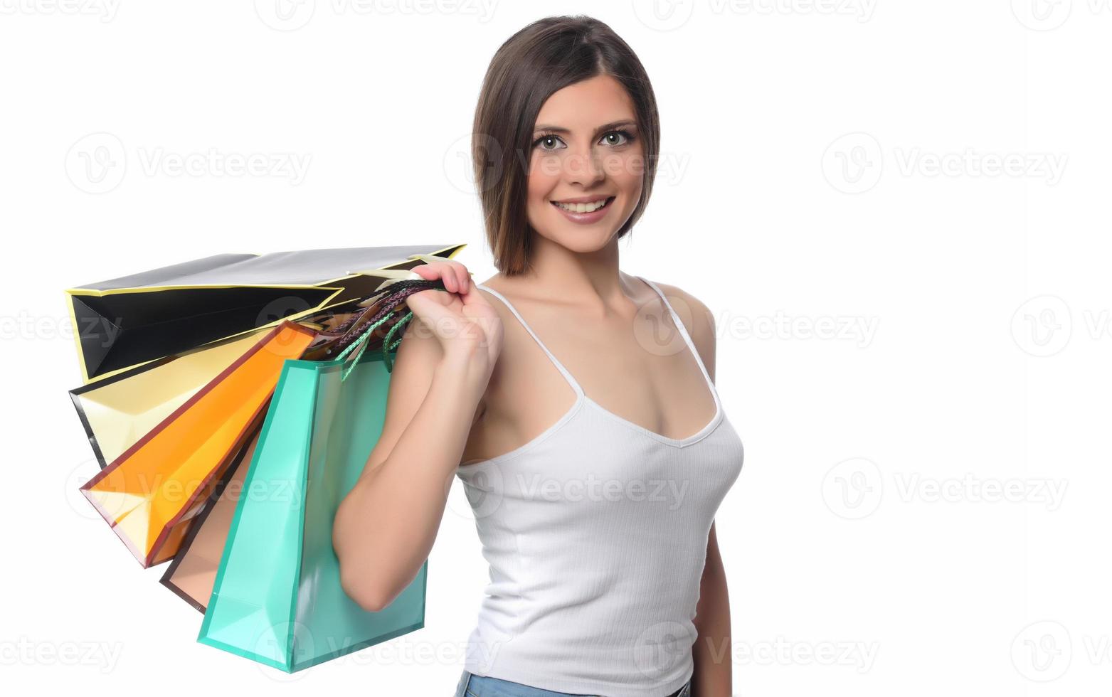 imagem de uma bela jovem morena posando com sacolas de compras e olhando para a câmera. conceito de compras. isolado foto