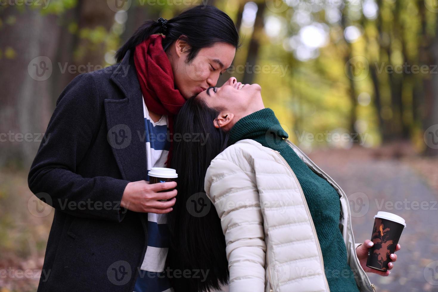 casal misto no parque curtindo um ao outro e bebendo café foto