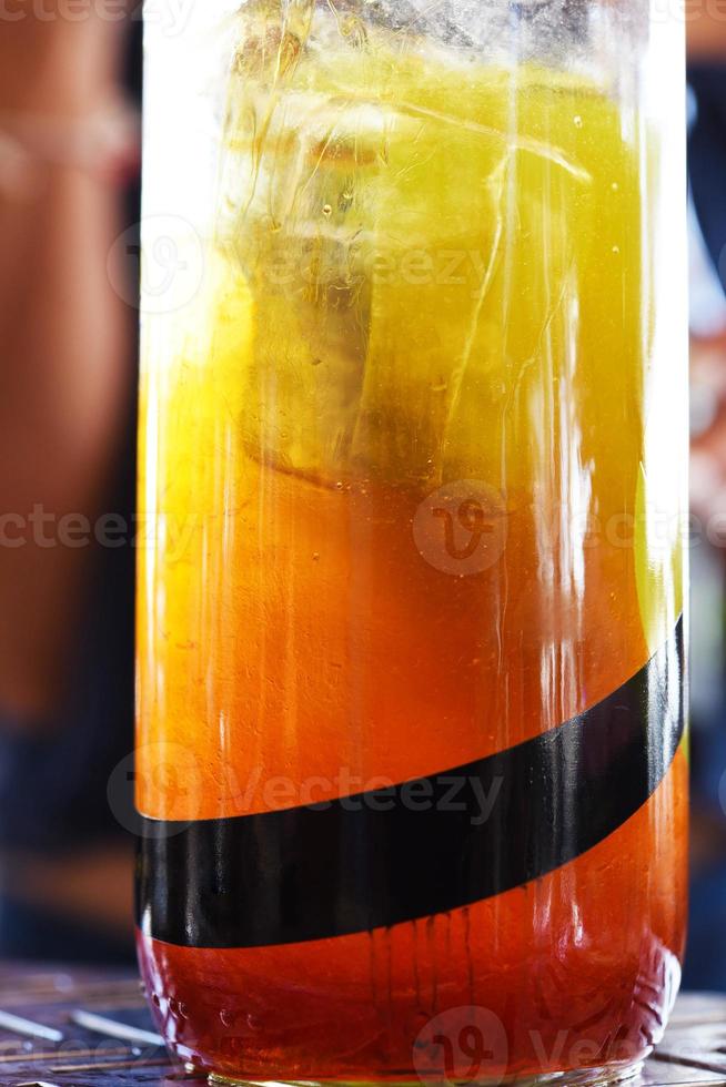 copo com suco refrescante no bar. coquetel cítrico com gelo, detalhes do coquetel de laranja foto