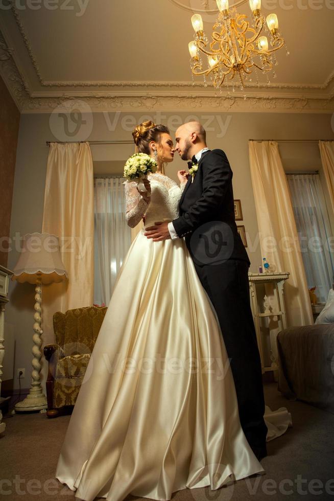 retrato vertical de um jovem e adorável casal recém-casado se abraçando foto