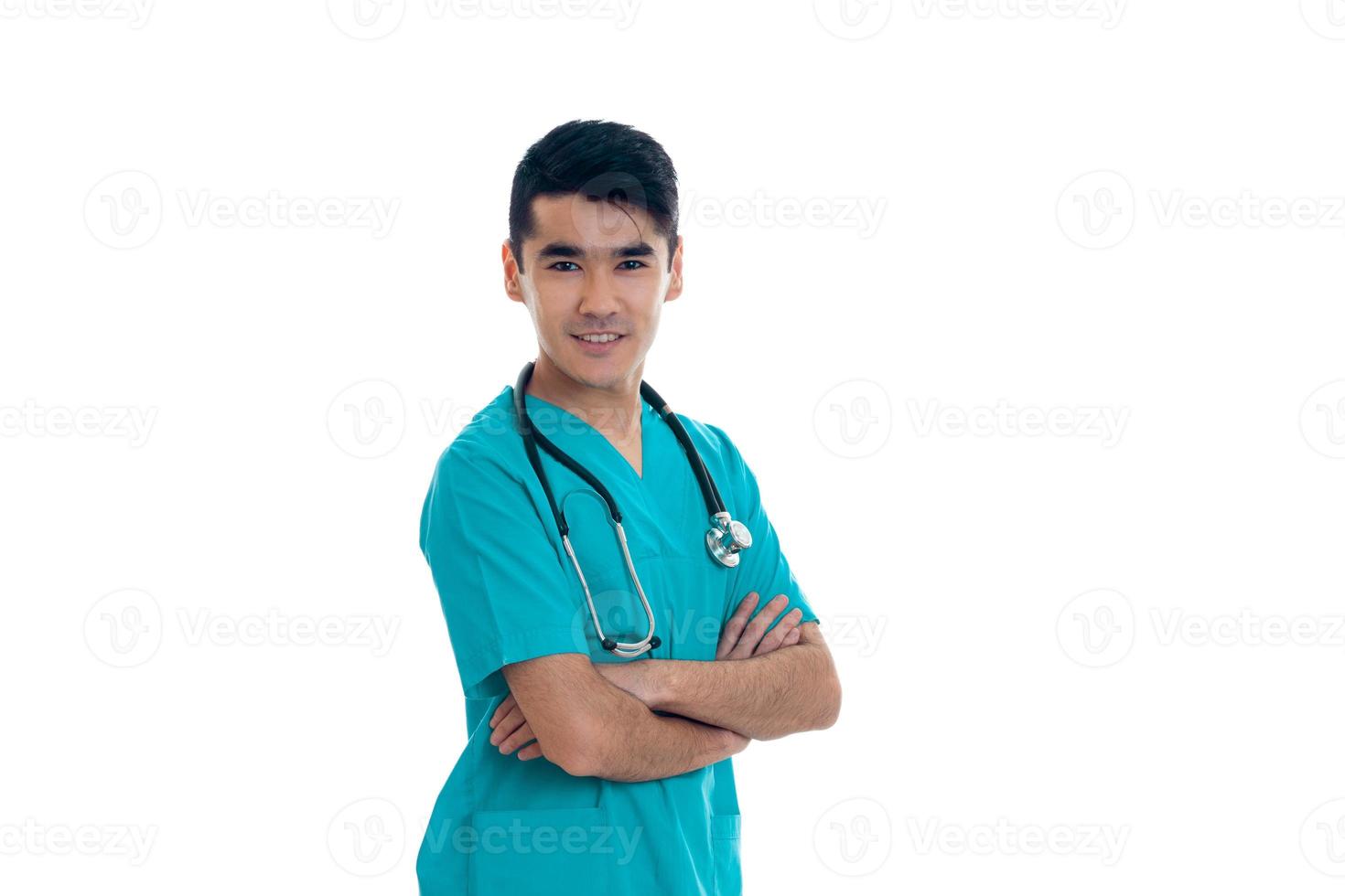 médico masculino de uniforme com estetoscópio sorrindo para a câmera isolada no fundo branco foto