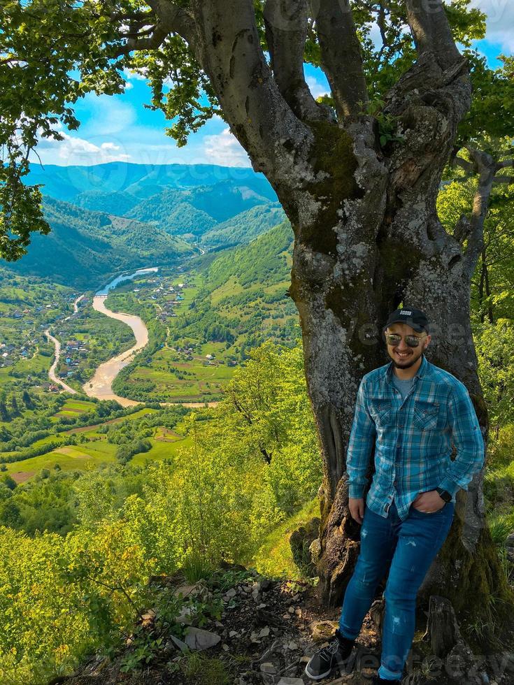 cara sorrindo perto de uma árvore foto