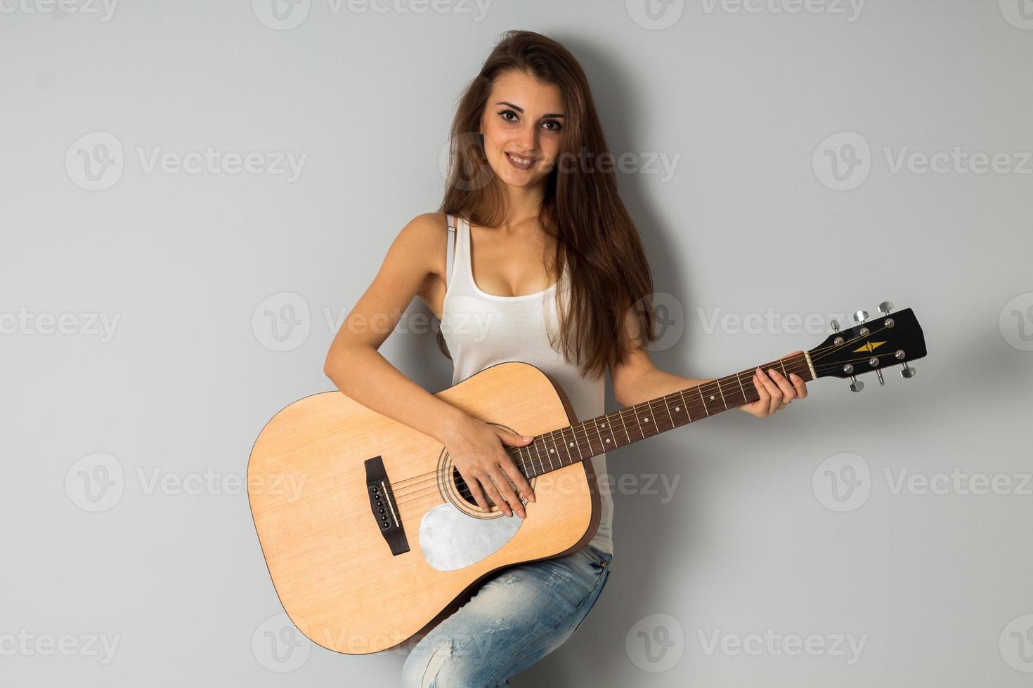 mulher sexy com seios grandes e guitarra nas mãos foto