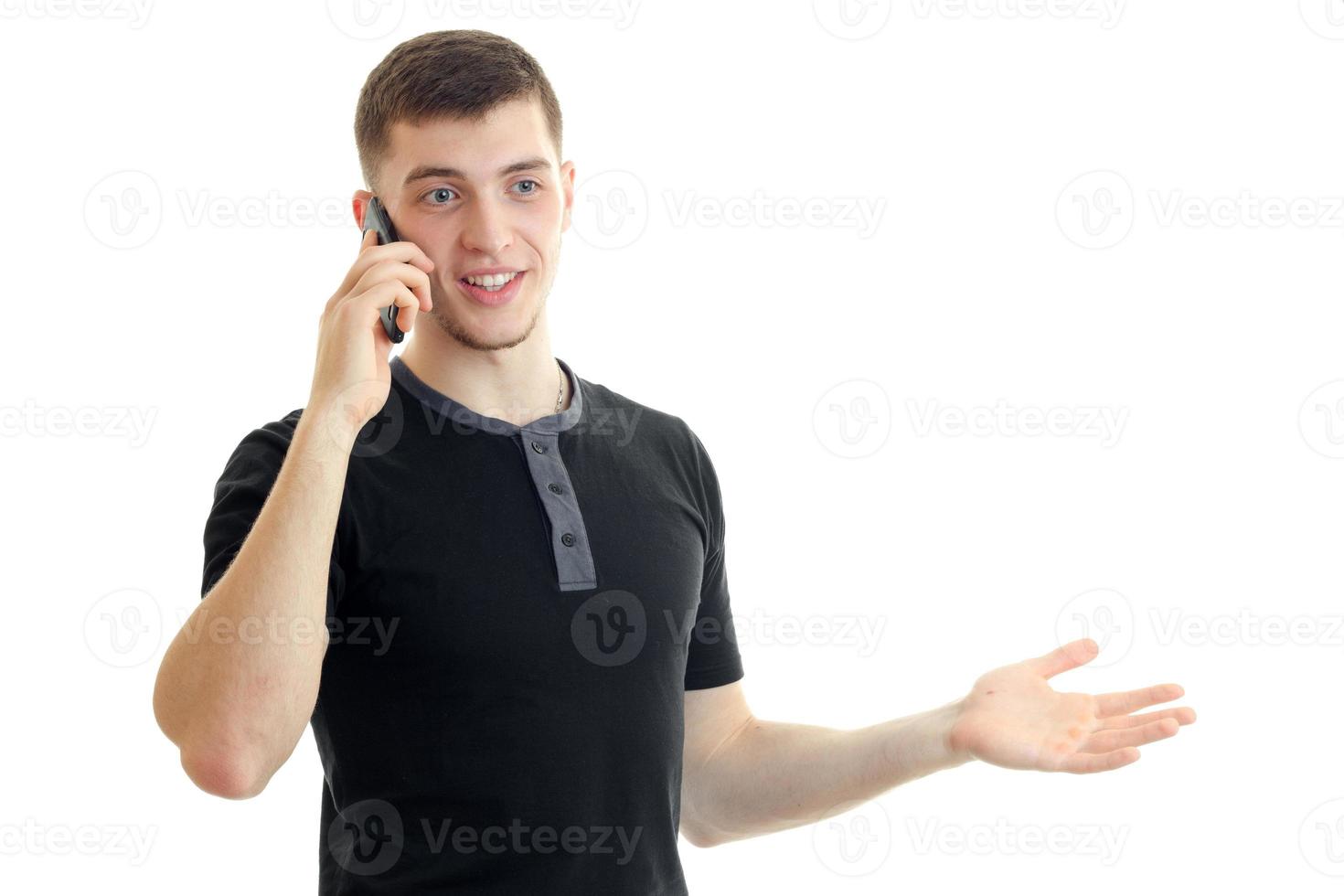 jovem bonito falando telefone e sorrindo foto