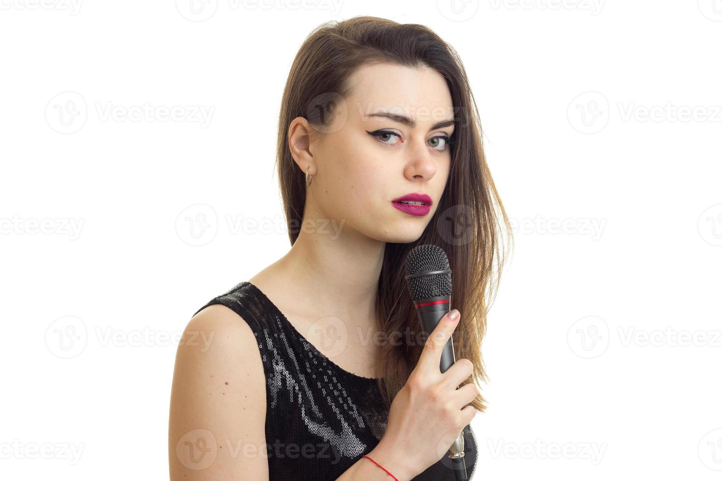 bela dama de vestido preto com microfone foto