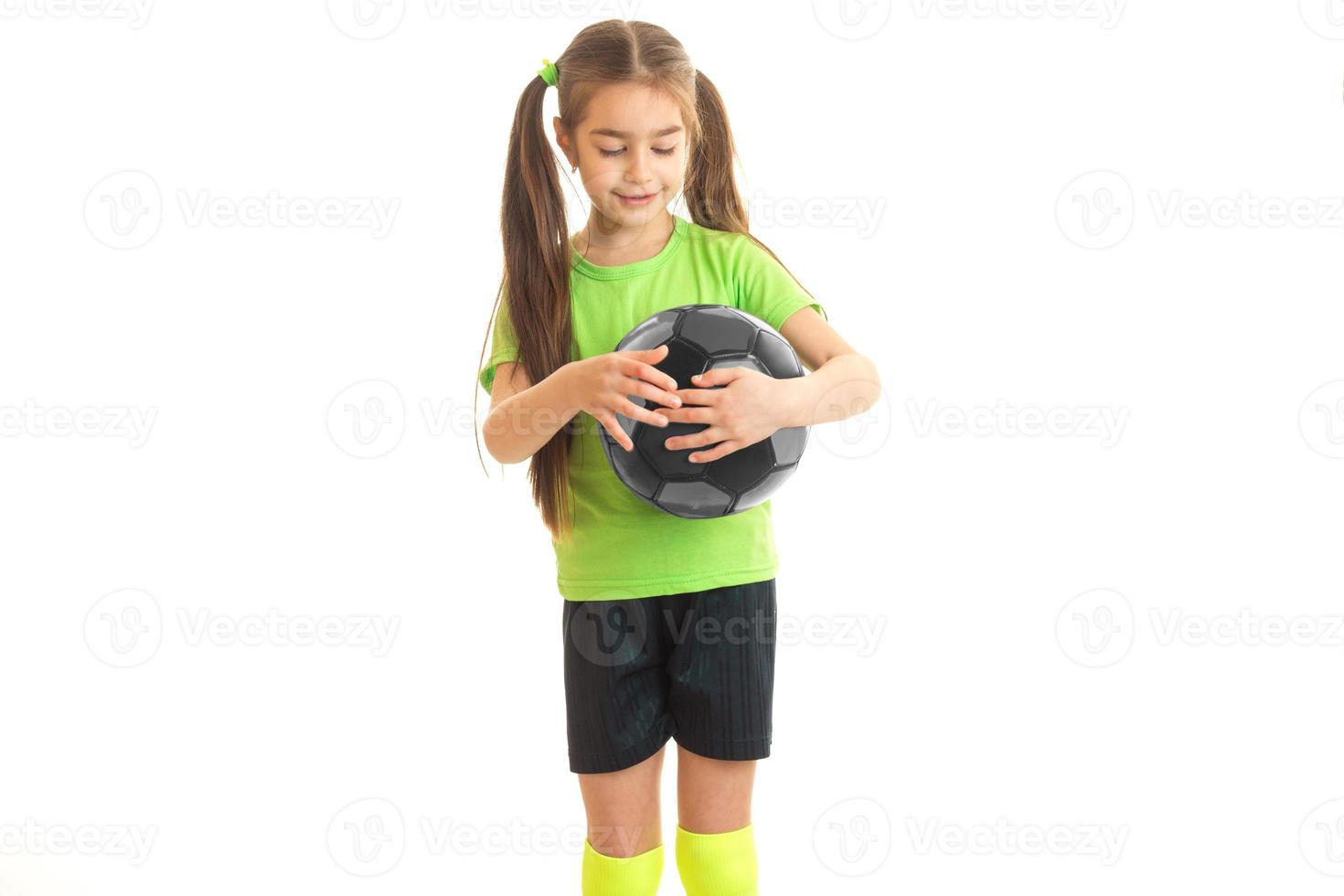 garotinha em uma camiseta brilhante e cauda segura bola no estúdio foto