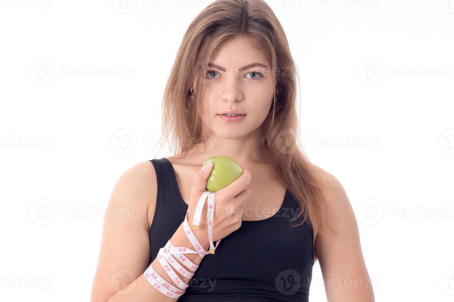 jovem atlética em pé de lado segurando uma maçã na mão foto