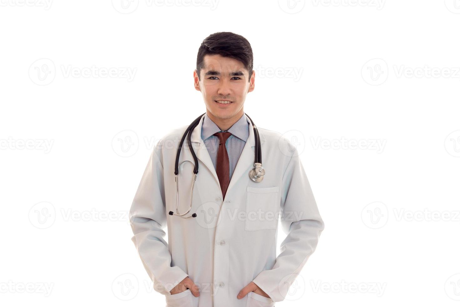 alegre médico masculino com estetoscópio em uniforme posando isolado no fundo branco foto