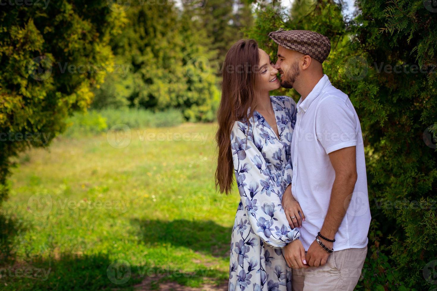 casal apaixonado abraça e sorri de mãos dadas no jardim verde foto