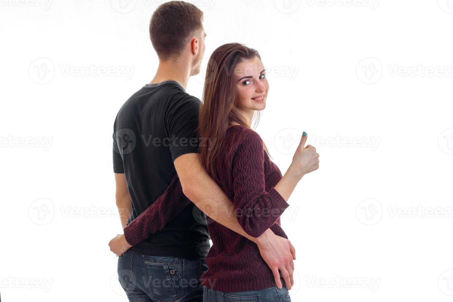 jovem casal abraçando a cintura e menina mostrando os polegares foto