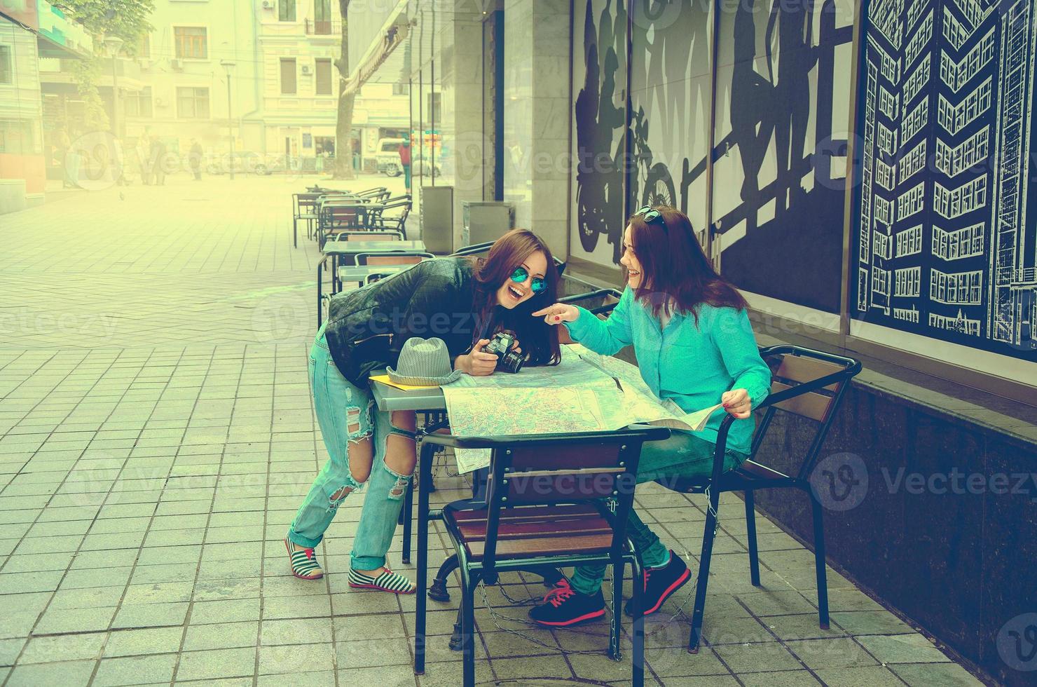 duas mulheres sentadas em uma mesa na rua foto