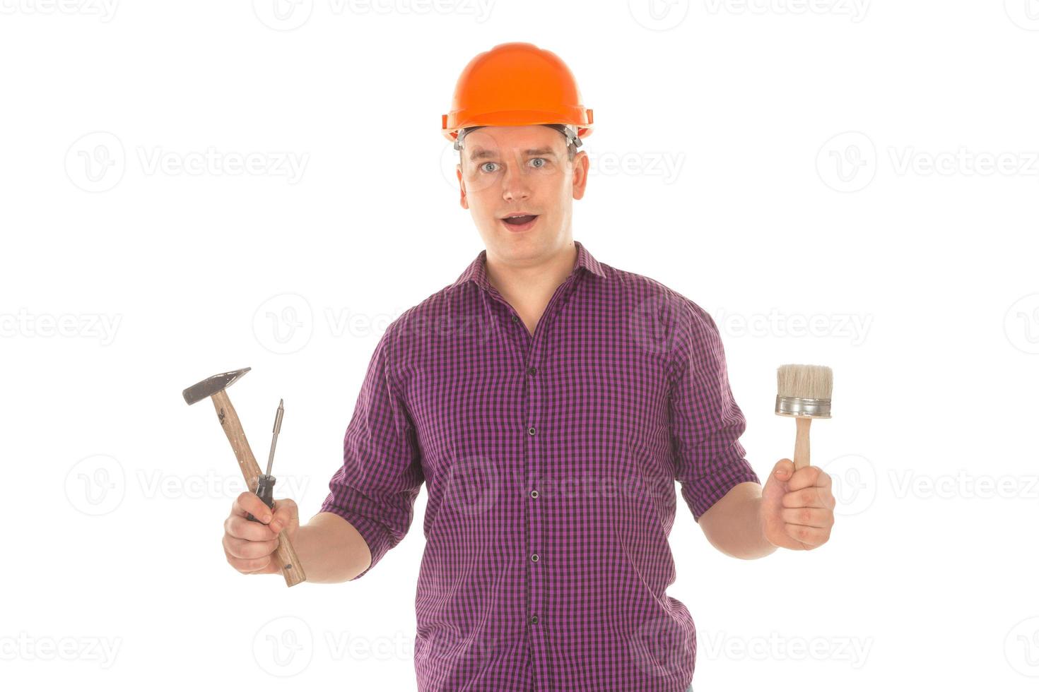 Construtor com ferramentas nas mãos foto