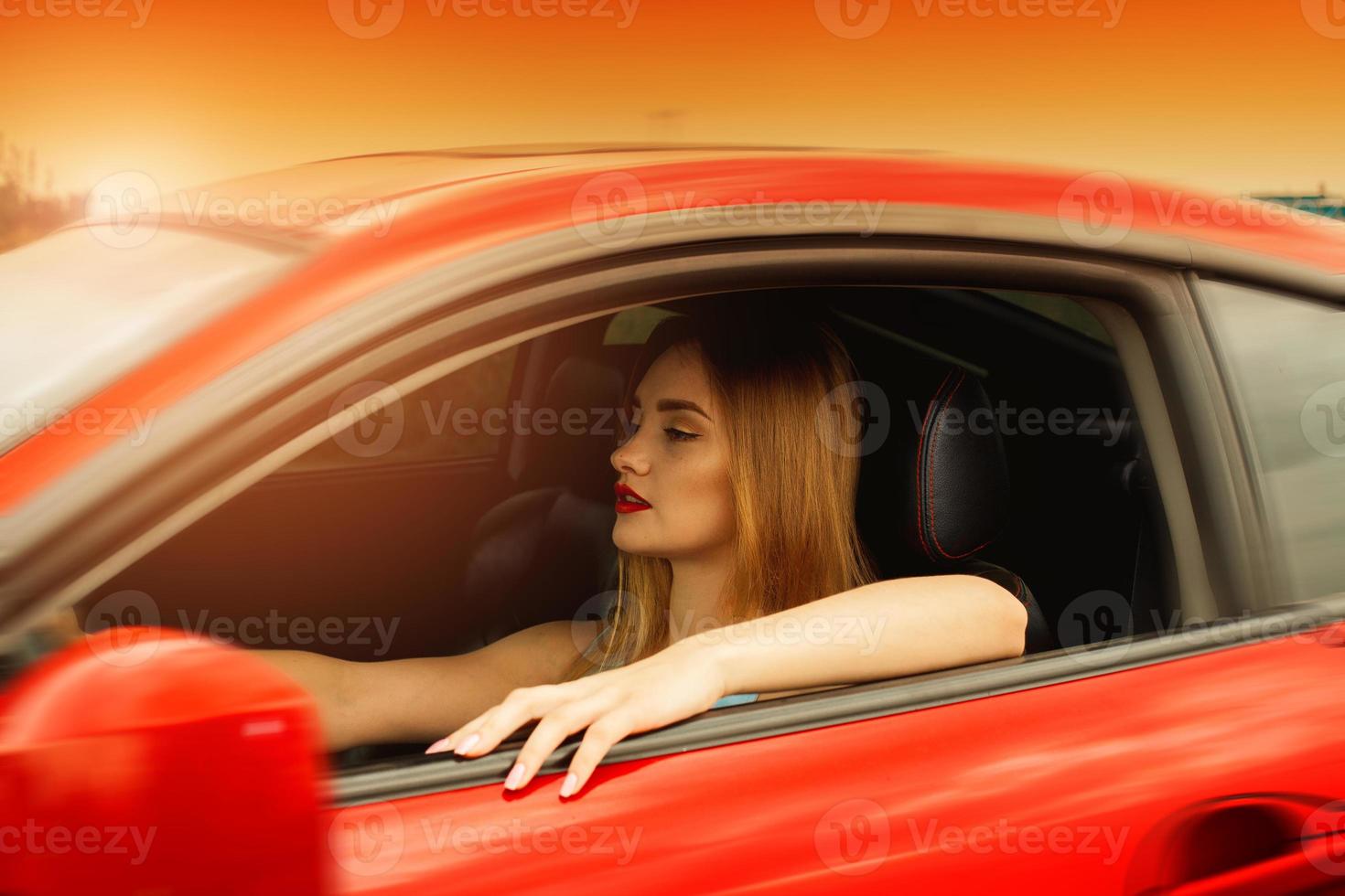 retrato do pôr do sol de uma jovem linda dirigindo um carro foto