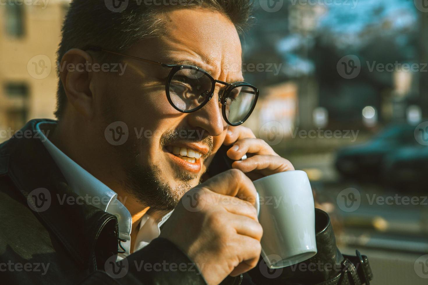 elegância masculino falando telefone e bebendo café foto