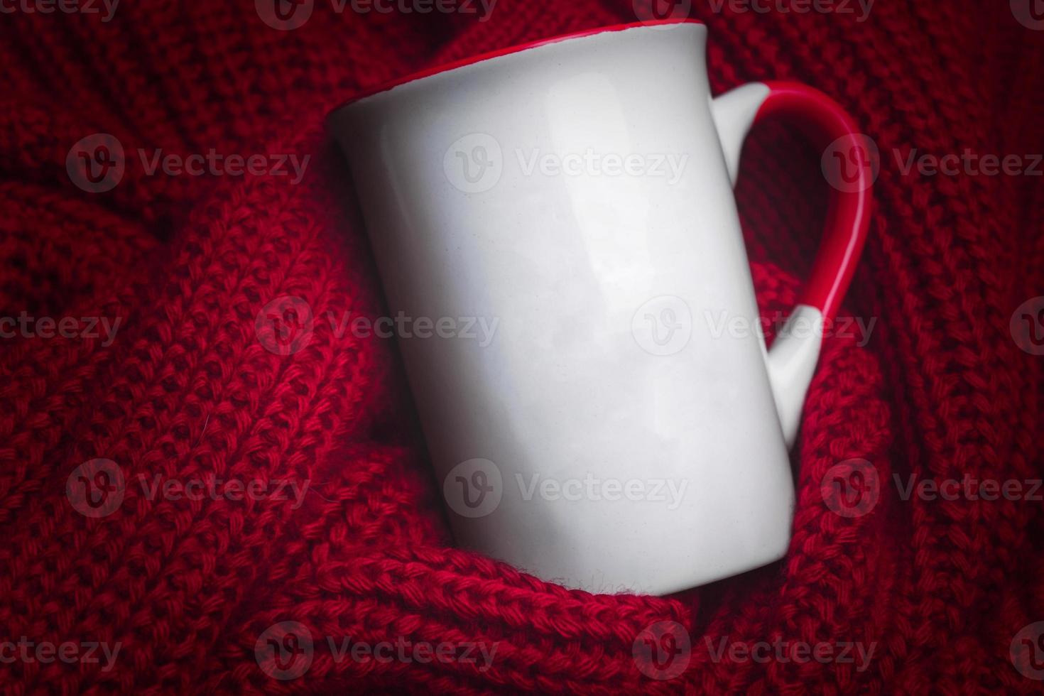 caneca branca para maquete deitado no aconchegante suéter vermelho. foto