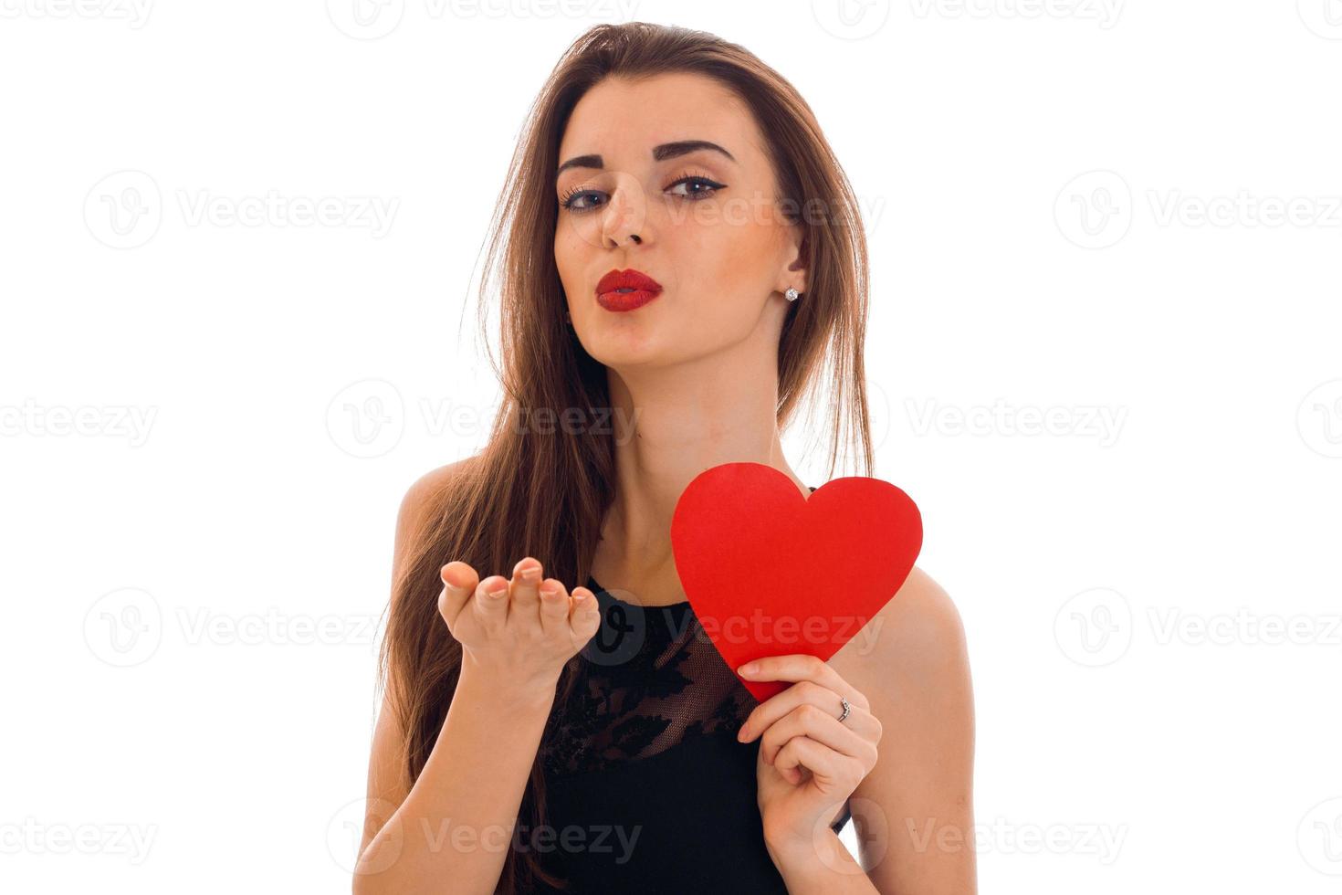 jovem mulher encantadora com lábios vermelhos se preparando para comemorar o dia dos namorados com o símbolo do coração no estúdio isolado no fundo branco foto