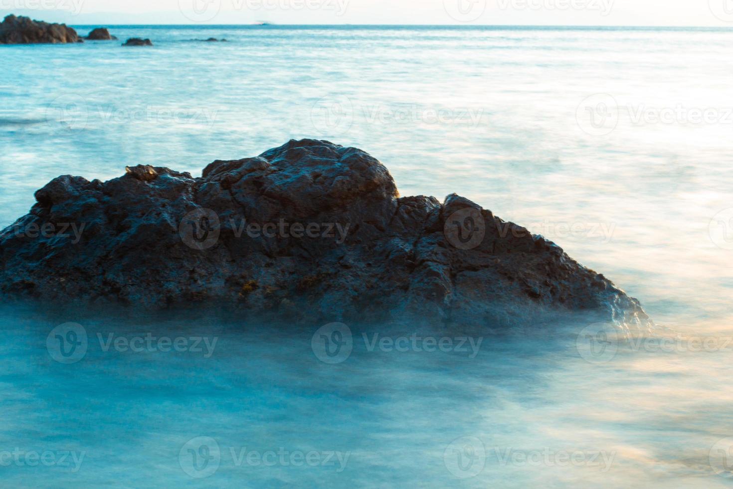 rochas nas ondas do mar azul foto