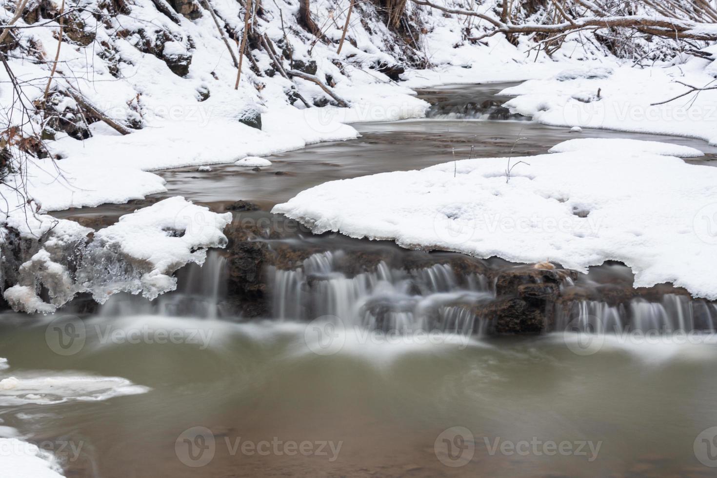 um pequeno rio de floresta rochosa no inverno foto