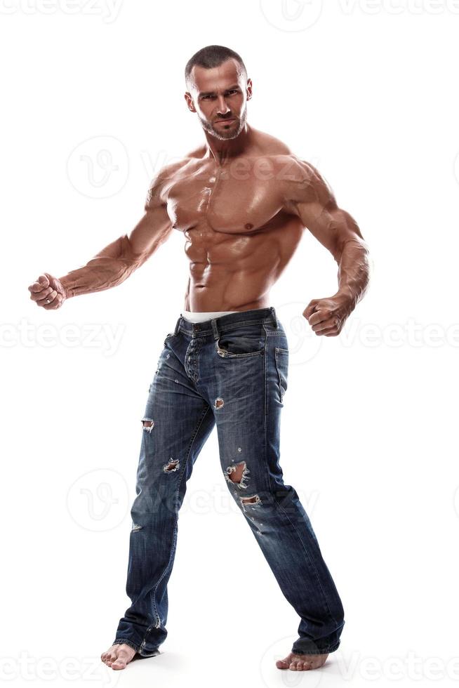 bonito homem musculoso vestindo jeans posando no estúdio foto