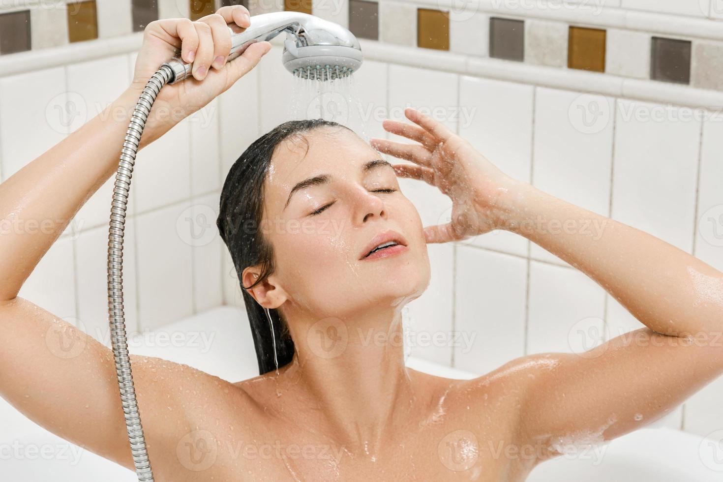 mulher lavando o cabelo no chuveiro no banheiro foto