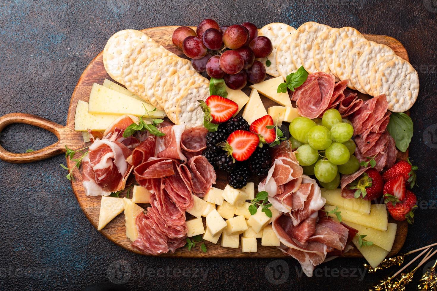 tábua de charcutaria com variedade de queijos e carnes foto