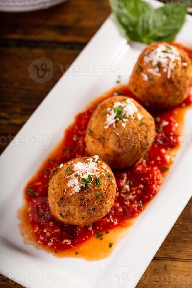 arancini, bolinhas de arroz italianas recheadas e cobertas com migalhas de pão foto