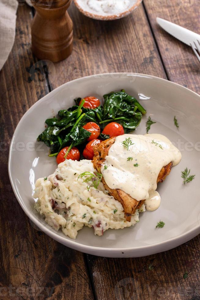 coxas de frango assadas servidas com molho cremoso e purê de batata foto