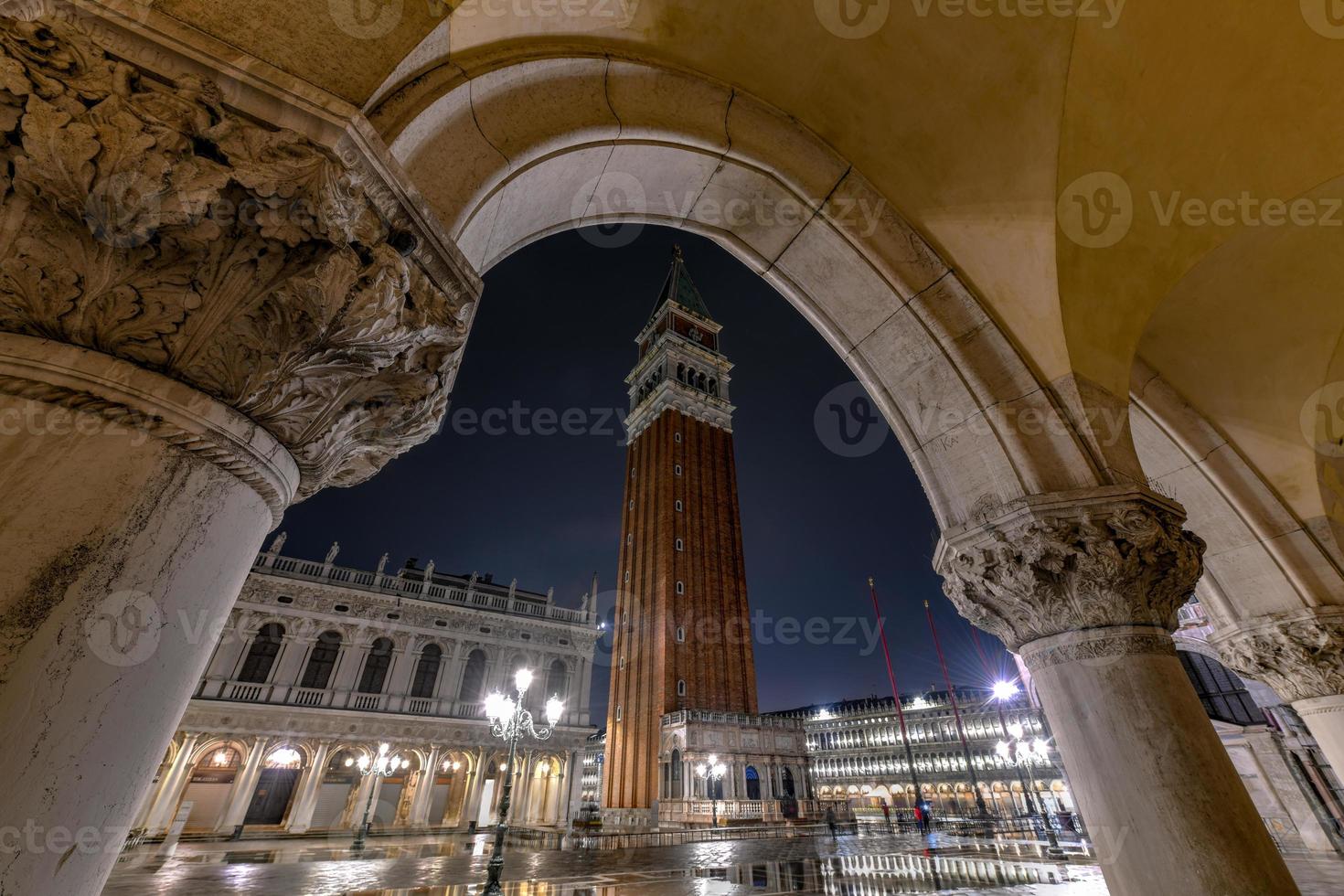 a torre do sino na praça de são marcos em veneza, itália à noite. foto
