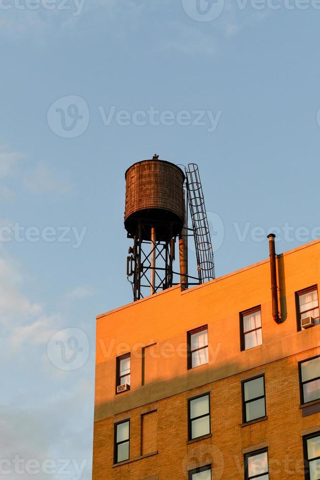 torre de água no telhado de um prédio na cidade de nova york. foto