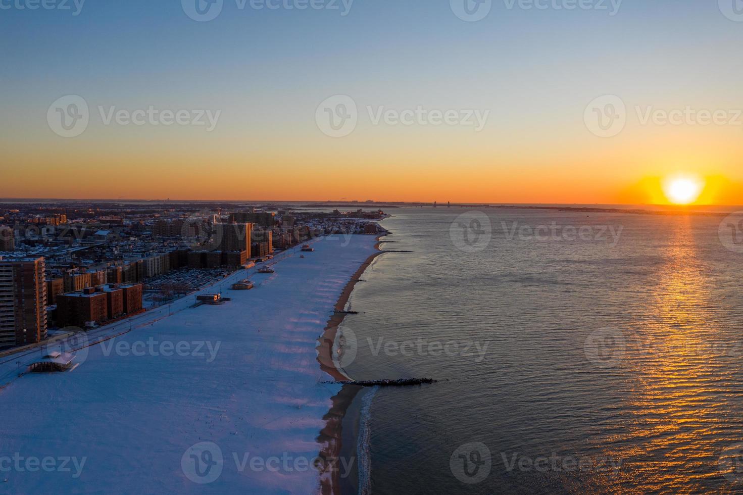 vista aérea de uma praia de coney island coberta de neve durante o inverno ao nascer do sol em brooklyn, nova york foto