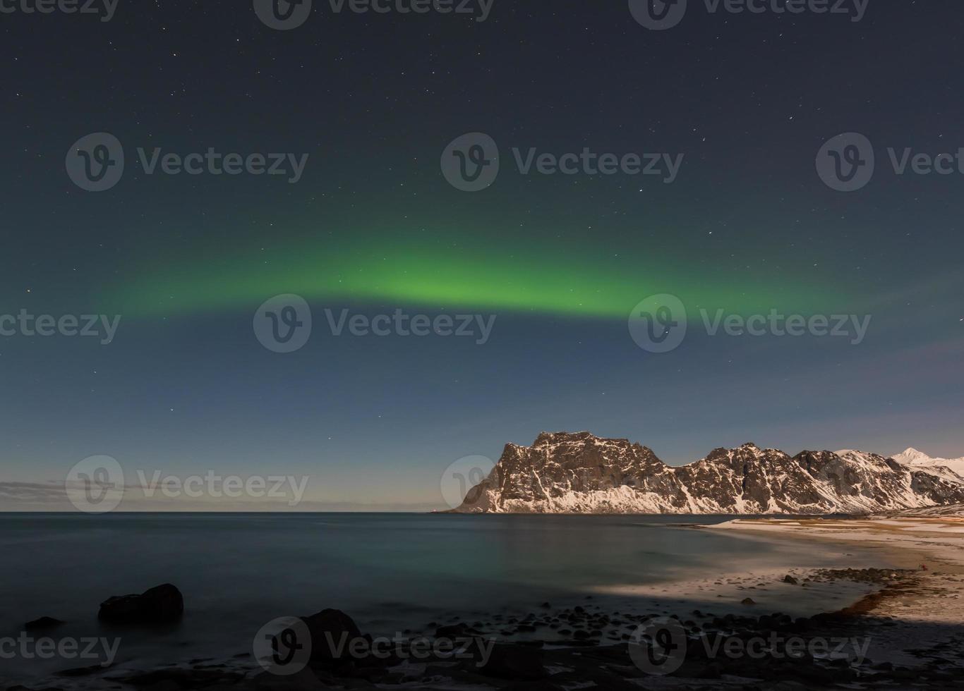 aurora boreal sobre o mar na praia de utakleiv, ilhas lofoten, noruega no inverno. foto