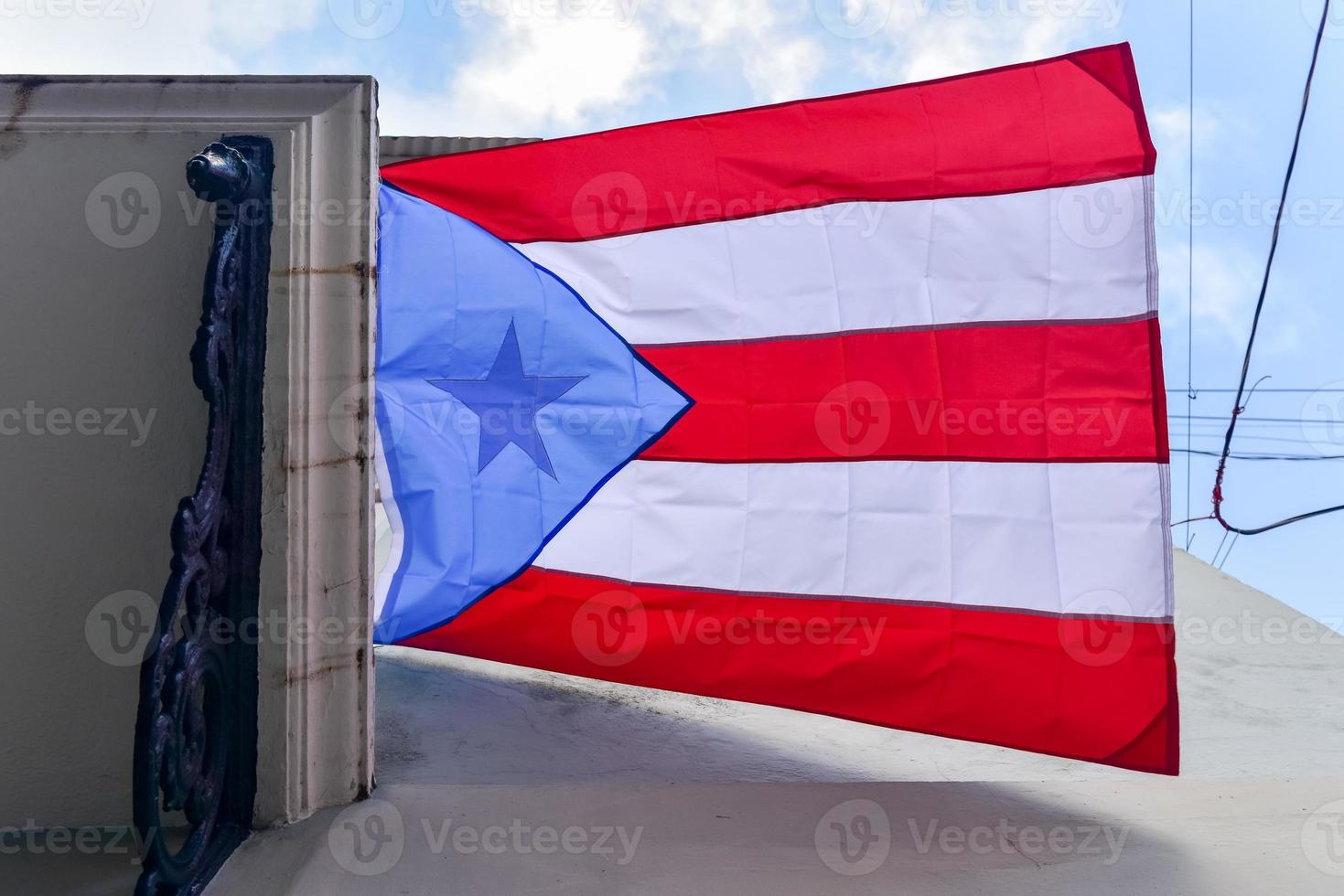 bandeira de porto rico pendurada em uma varanda em san juan, balançando ao vento. foto