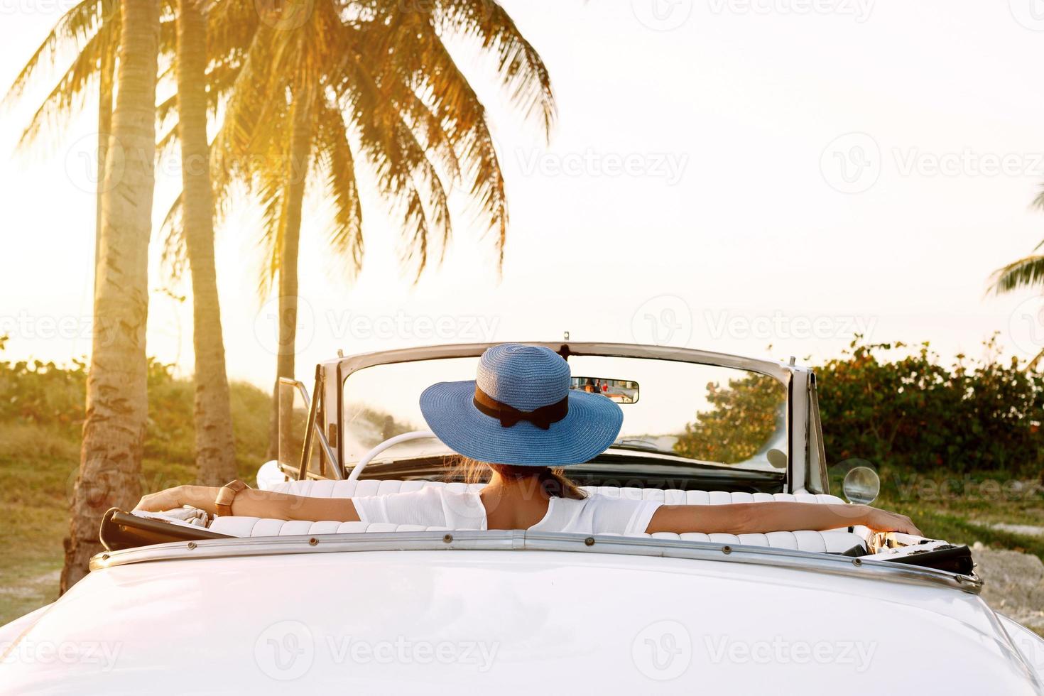 linda mulher de chapéu azul e cabriolet retrô branco foto