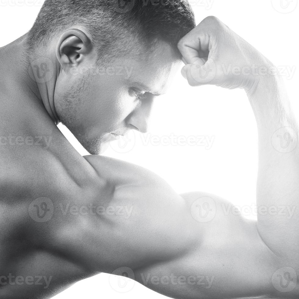 jovem musculoso mostrando seu bíceps em branco foto