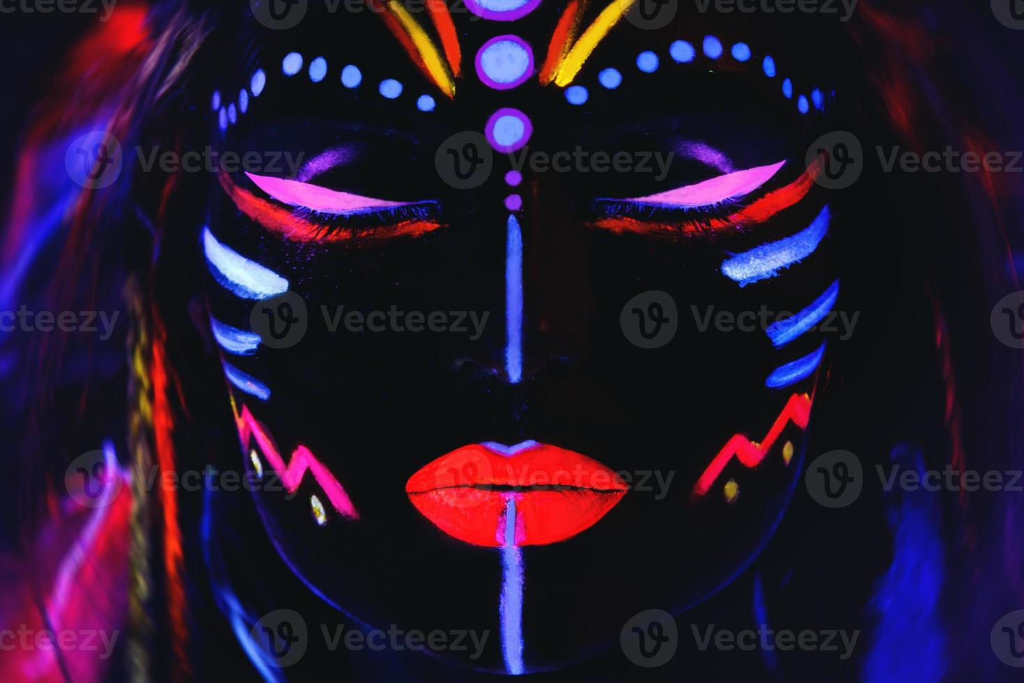 modelo em imagem de nativo americano com maquiagem neon, feita de tinta fluorescente em luz ultravioleta. foto