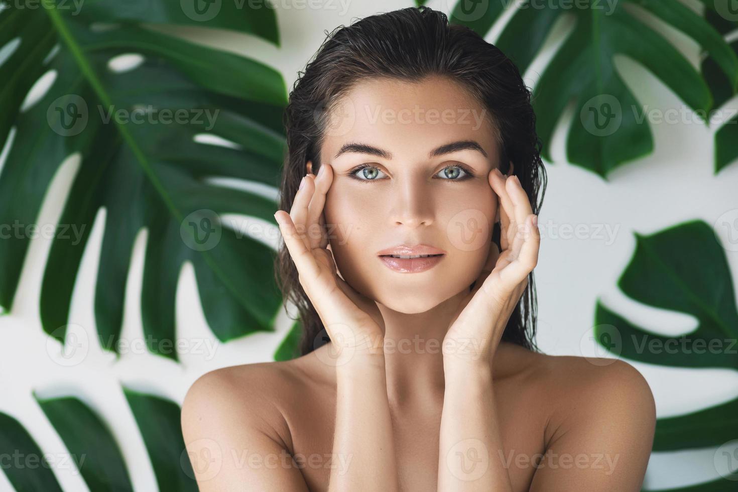 retrato de mulher jovem e bonita com pele lisa perfeita em folhas tropicais foto