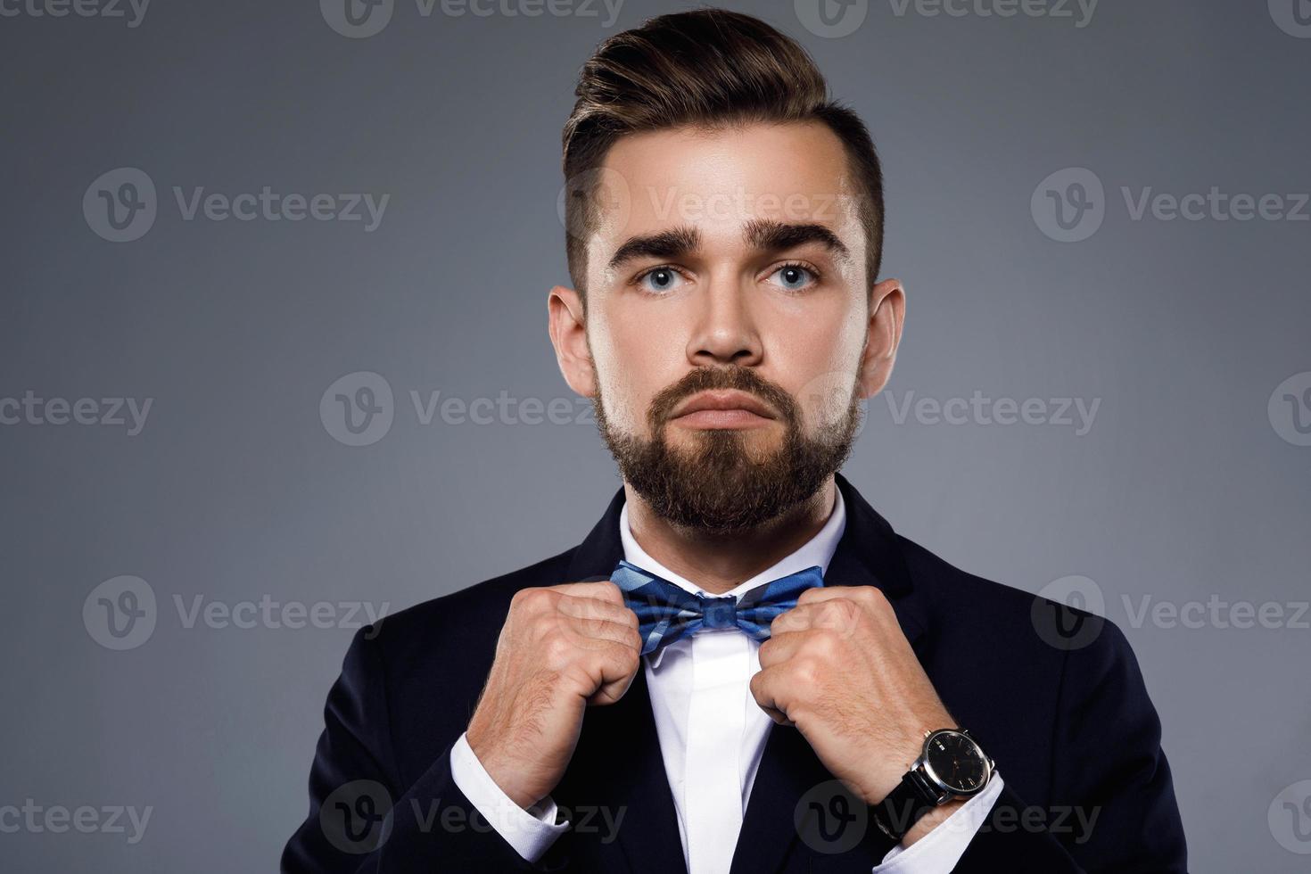 homem bonito elegante vestindo um terno clássico com gravata borboleta foto